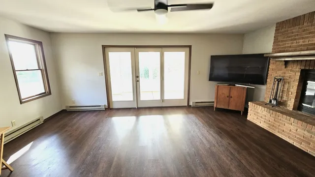 a living room with furniture a flat screen tv and a window