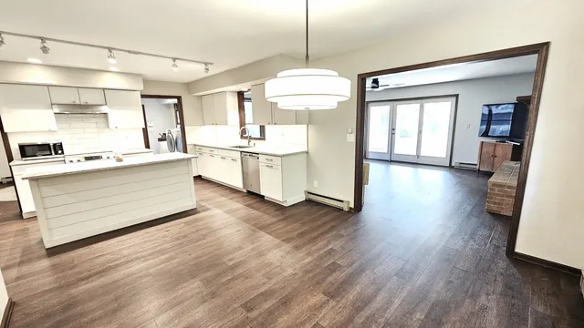 a kitchen with a stove a sink a dining table and chairs