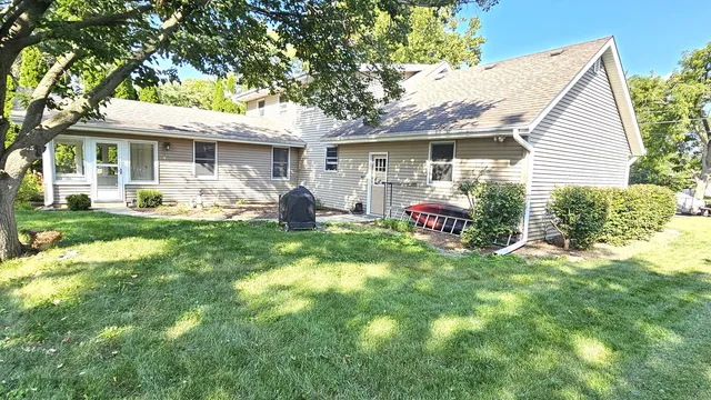 a front view of a house with a garden and trees