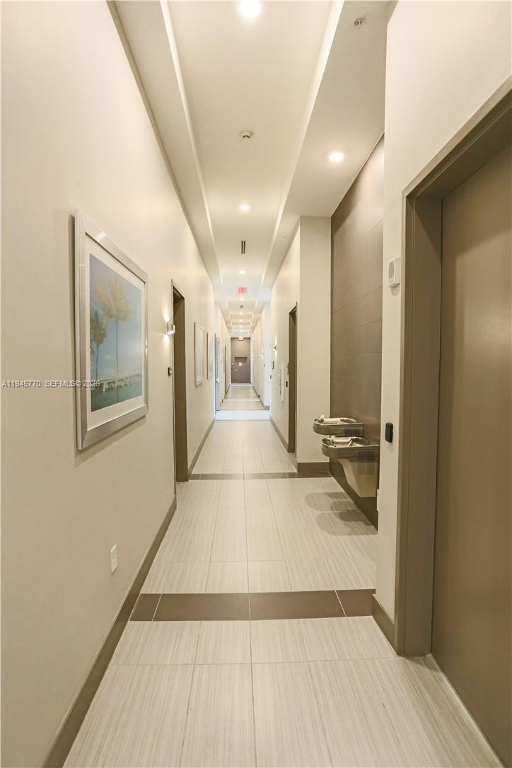 117 Southwest 10th Street, Unit 2206 Miami, FL 33130 - Photo 8 of 22 a view of a hallway with wooden floor and a bathroom