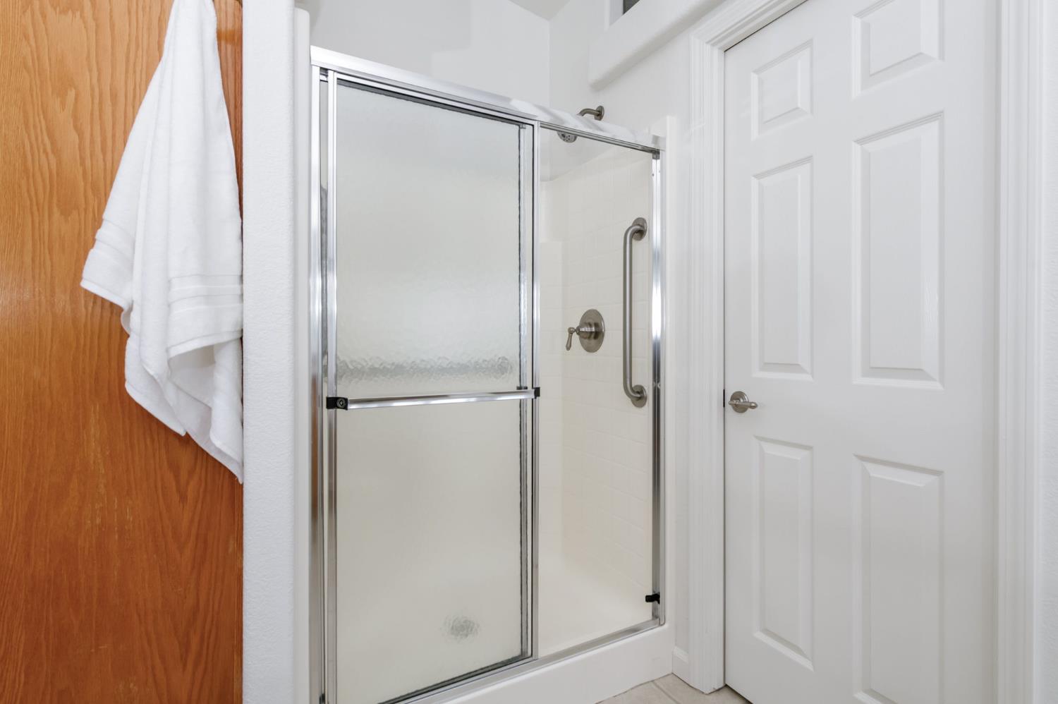 8646 Cairo Avenue Laton, CA 93242 - Photo 19 of 38 a bathroom with a shower and a glass door