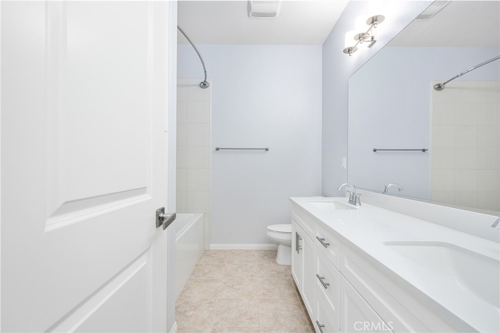 94 Capricorn Irvine, CA 92618 - Photo 28 of 47 a bathroom with a double vanity sink and mirror with toilet