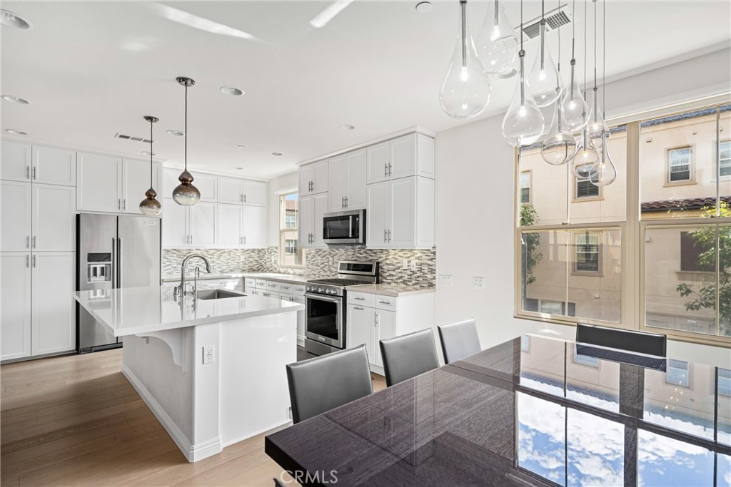94 Capricorn Irvine, CA 92618 - Photo 6 of 47 a living room with stainless steel appliances kitchen island furniture and a chandelier