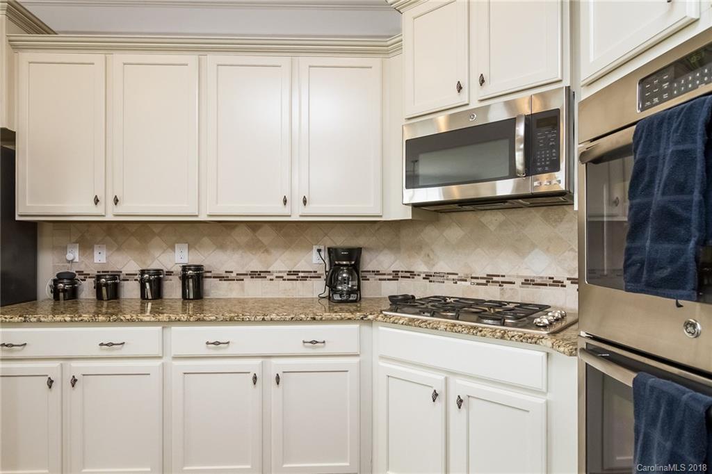 1841 Larkspur Way Tega Cay, SC 29708 - Photo 15 of 27 a kitchen with stainless steel appliances granite countertop white cabinets granite counter tops and a wooden floor