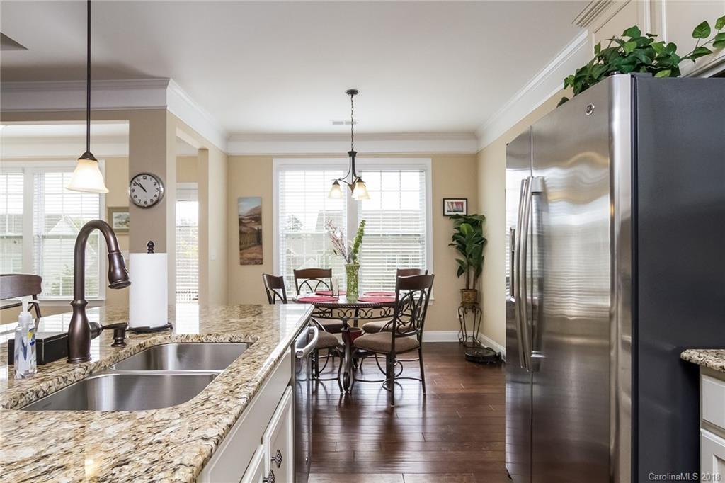 1841 Larkspur Way Tega Cay, SC 29708 - Photo 17 of 27 a kitchen with kitchen island granite countertop a sink cabinetry a dining table and chairs