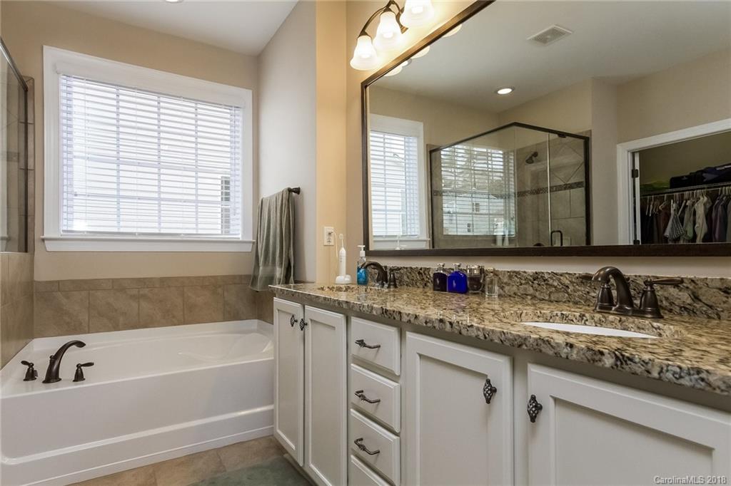 1841 Larkspur Way Tega Cay, SC 29708 - Photo 20 of 27 a bathroom with a granite countertop tub a sink and a window