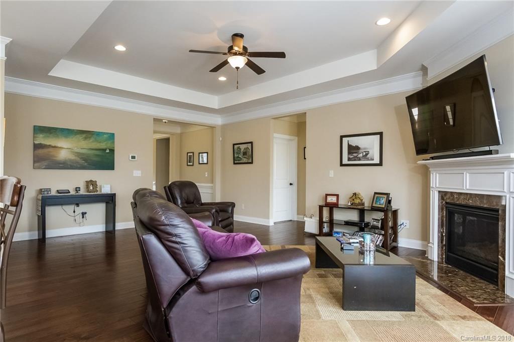 1841 Larkspur Way Tega Cay, SC 29708 - Photo 10 of 27 a living room with furniture a fireplace a flat screen tv and kitchen view