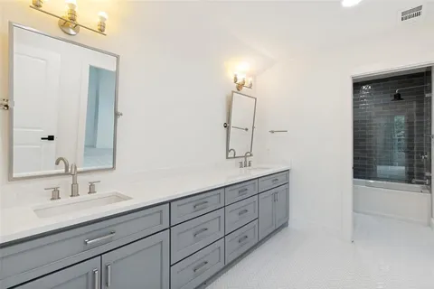 a bathroom with double vanity sink and mirror