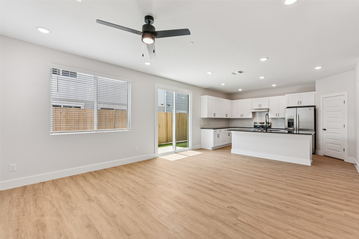 a view of kitchen with refrigerator sink and cabinets