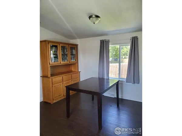 a kitchen with kitchen island granite countertop a sink cabinets and a wooden floor