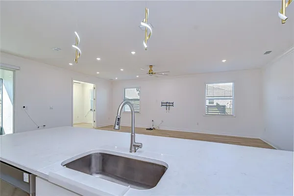 a view of a kitchen from an empty room with a fireplace