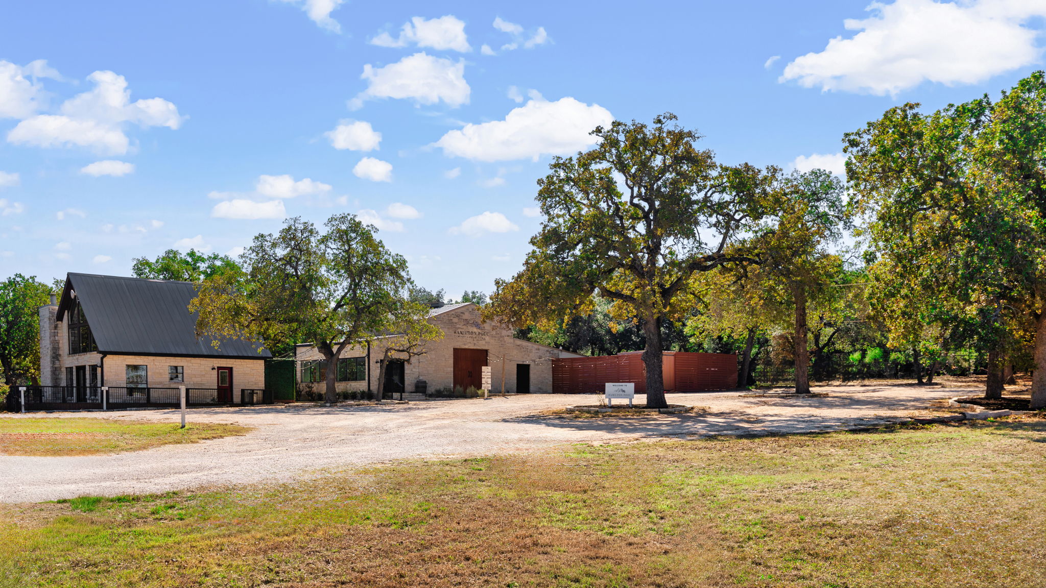 25711 Hamilton Pool Road Round Mountain, TX 78663 - Photo 2 of 39 a view of a swimming pool with an outdoor seating and a yard