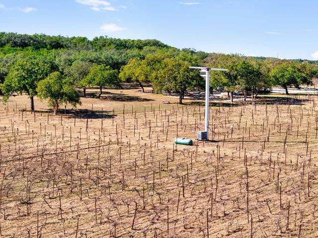 an aerial view of residential houses with outdoor space and trees