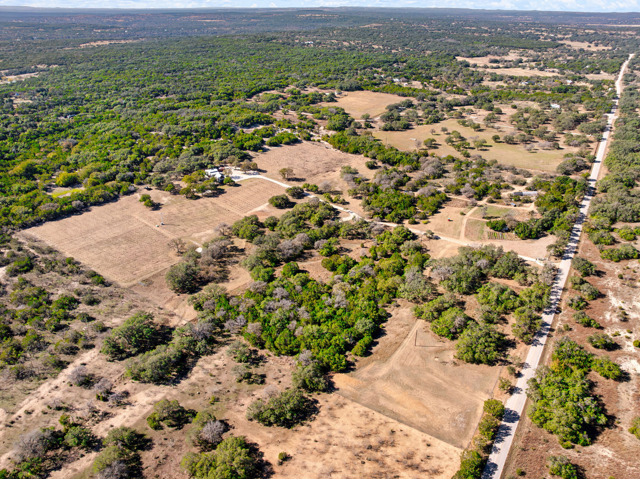 25711 Hamilton Pool Road Round Mountain, TX 78663 - Photo 27 of 39 an aerial view of residential houses with outdoor space and trees