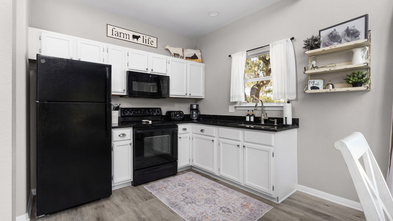 25711 Hamilton Pool Road Round Mountain, TX 78663 - Photo 36 of 40 a kitchen with stainless steel appliances a refrigerator a stove a microwave and cabinets