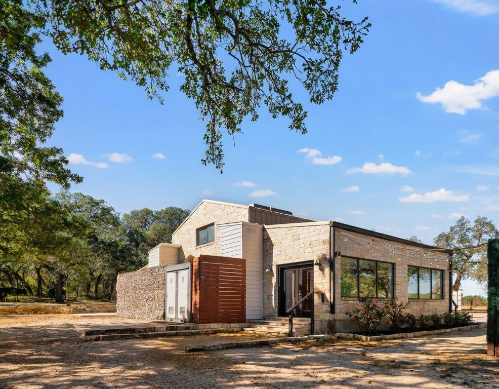 25711 Hamilton Pool Road Round Mountain, TX 78663 - Photo 7 of 40 a view of a house with a tree next to a yard