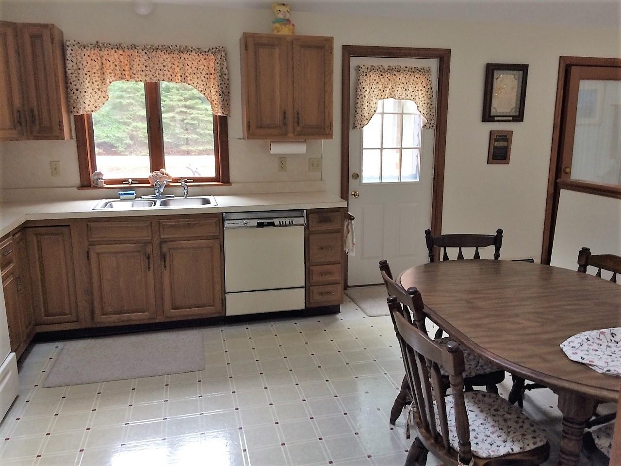 30 Lumbert Mill Road Centerville, MA 02632 - Photo 6 of 19 a kitchen with granite countertop a stove a sink a dining table and chairs