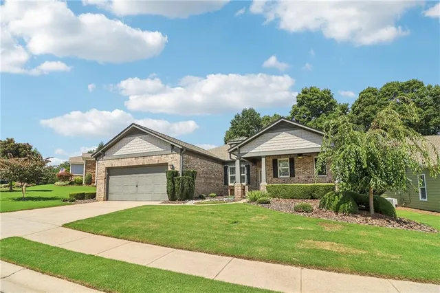 a front view of a house with a garden and yard