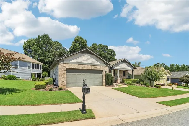 a front view of a house with a garden and trees