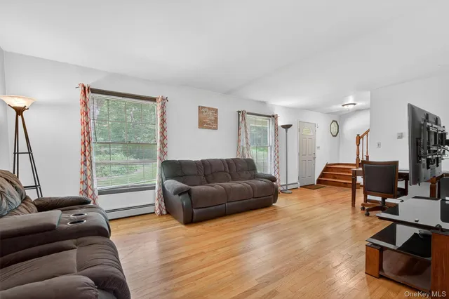 a living room with furniture and a flat screen tv with wooden floor
