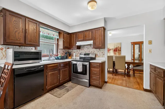 a kitchen with stainless steel appliances granite countertop a stove a sink and dishwasher with wooden cabinets