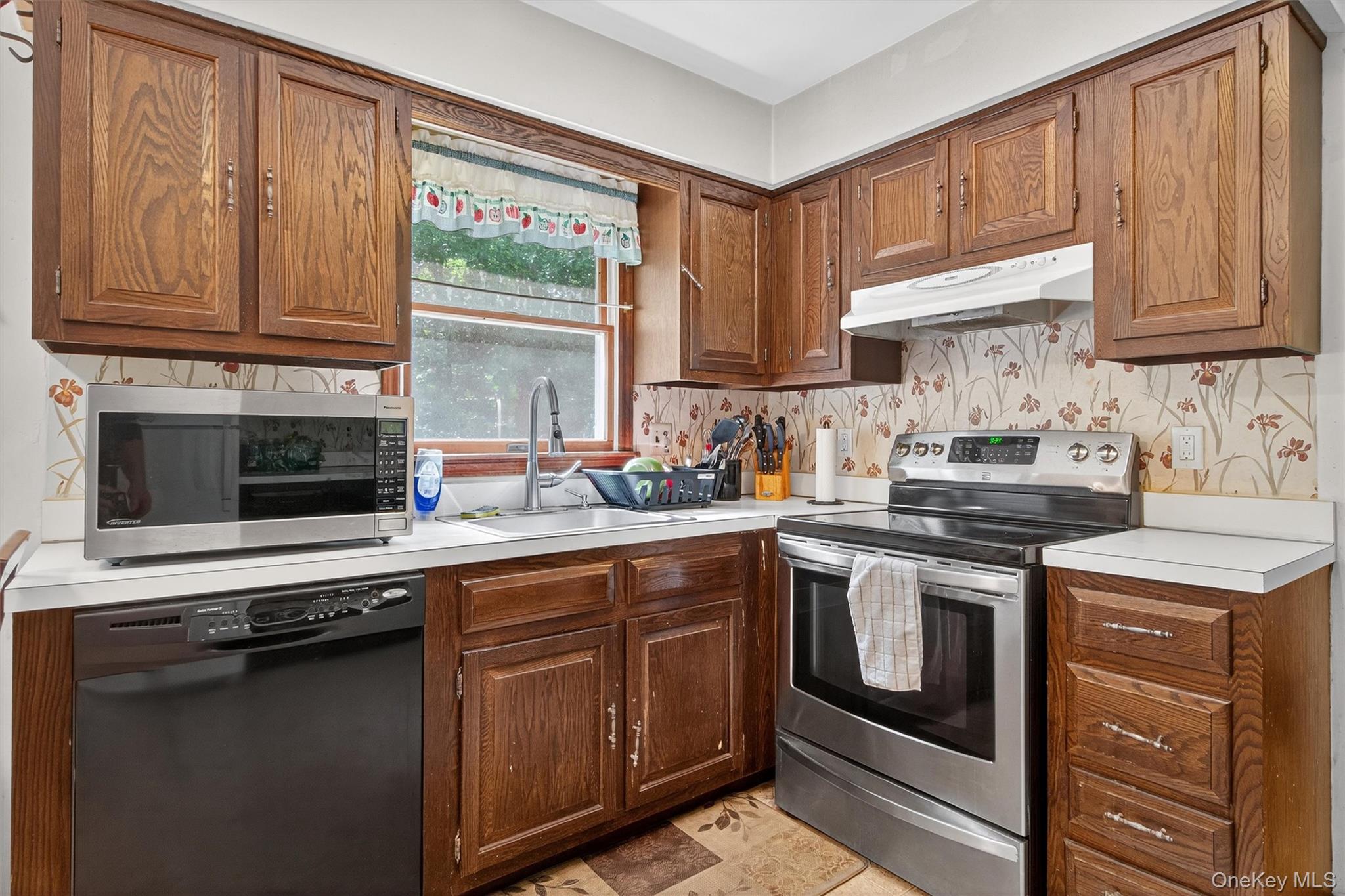 300 Estrada Road Central Valley, NY 10917 - Photo 30 of 30 a kitchen with stainless steel appliances granite countertop a stove a sink and dishwasher with wooden cabinets