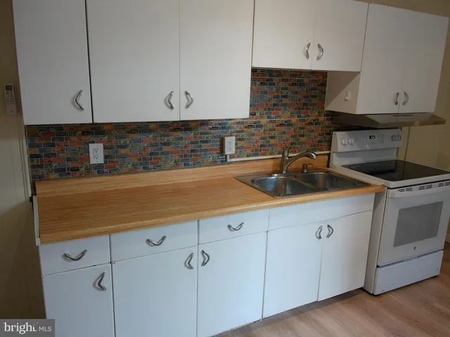 a stove top oven sitting inside of a kitchen