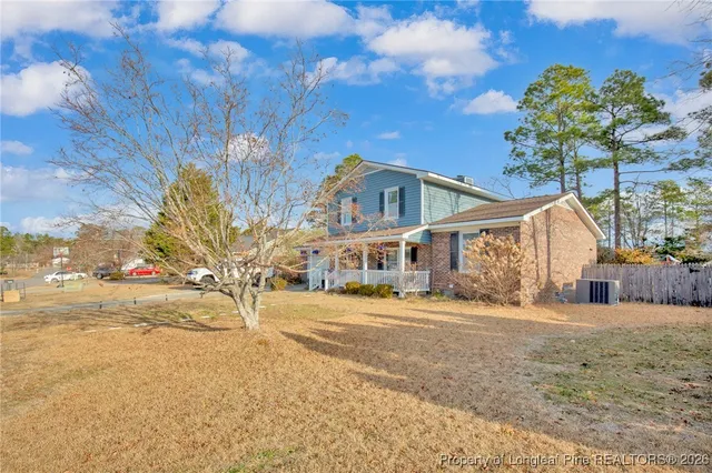 a front view of a house with a yard and trees