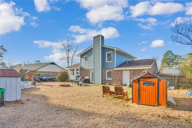 a front view of a house with a yard and covered with snow