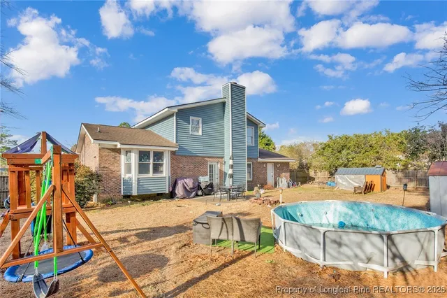 a view of a house with swimming pool and sitting area