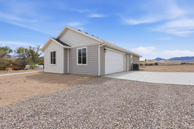 157 West 100 South Joseph, UT 84739 - Photo 4 of 30 View of home's exterior with a mountain view, driveway, board and batten siding, and an attached garage