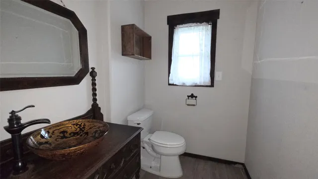 a bathroom with a toilet sink and mirror