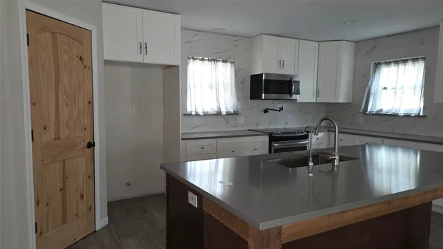 a kitchen with stainless steel appliances granite countertop a sink a stove and a refrigerator