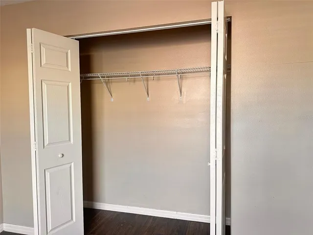 a view of a livingroom with a chandelier fan and wooden floor