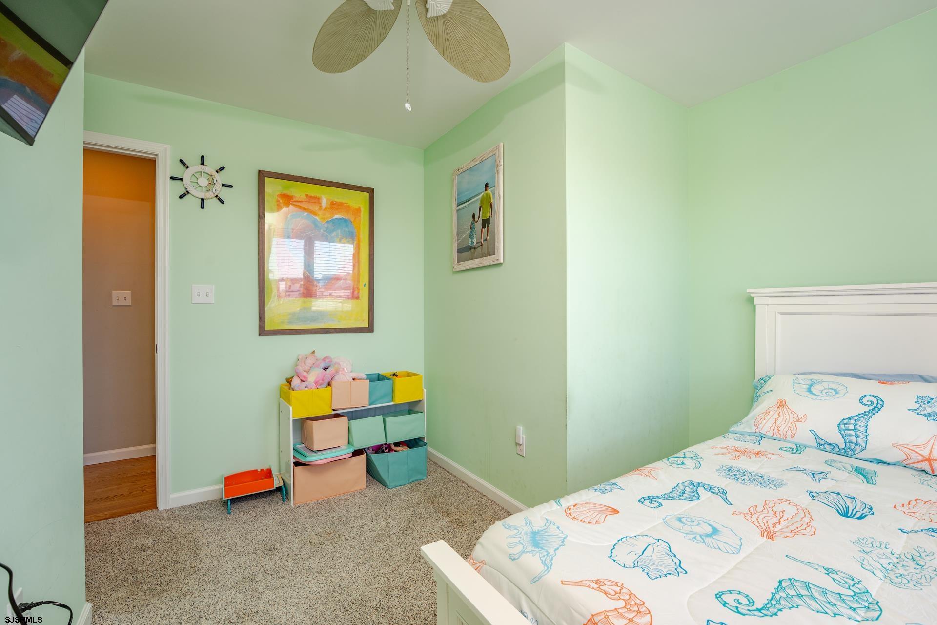 703 Bobby Jones Road Brigantine, NJ 08203 - Photo 11 of 34 a bedroom with a bed and a chandelier