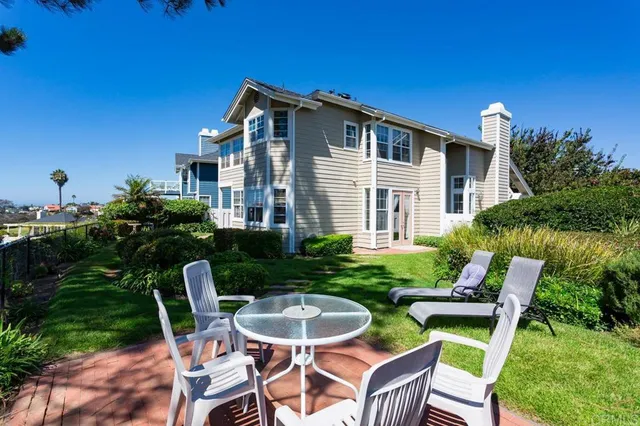 a patio with table and chairs and potted plants
