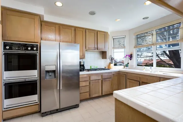 a kitchen with a refrigerator sink and cabinets