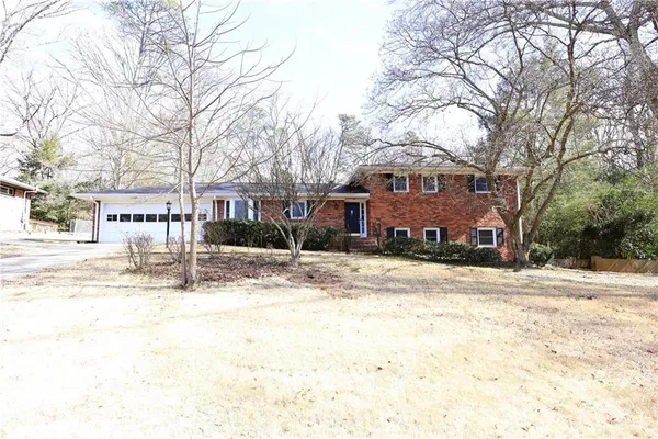 a front view of a house with a yard covered with snow