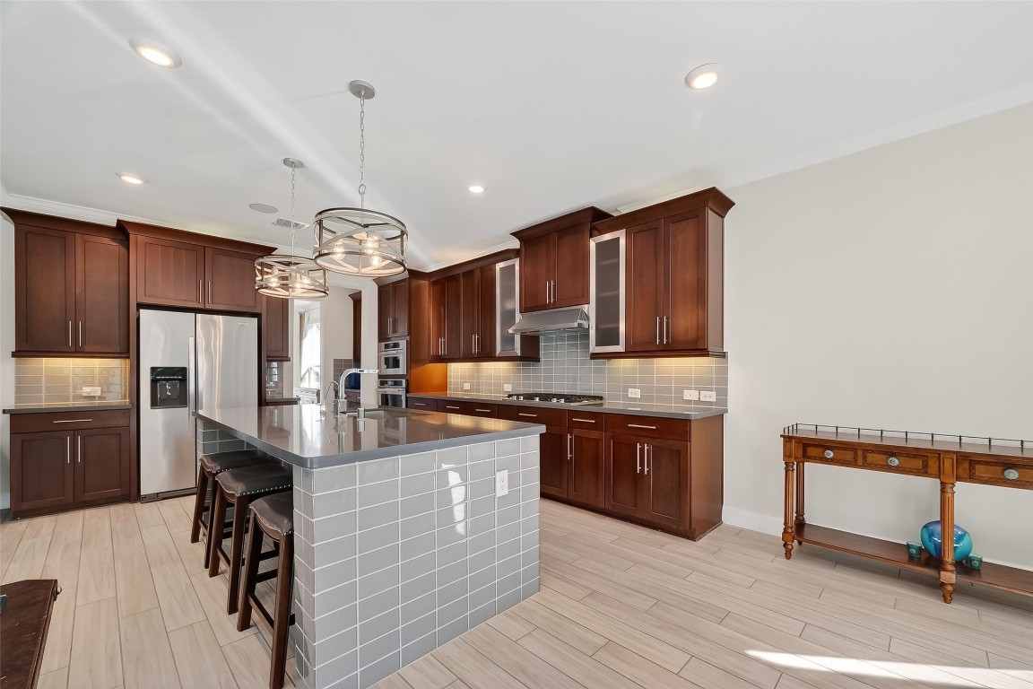 51 Scepter Ridge Sugar Land, TX 77498 - Photo 18 of 46 a kitchen with stainless steel appliances granite countertop a refrigerator a stove and a wooden floors