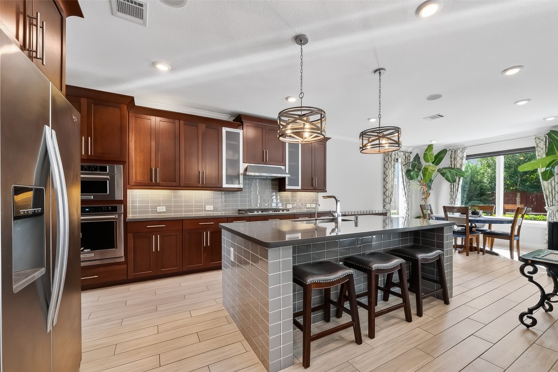 51 Scepter Ridge Sugar Land, TX 77498 - Photo 5 of 46 a kitchen with stainless steel appliances granite countertop a stove a refrigerator and a wooden cabinets