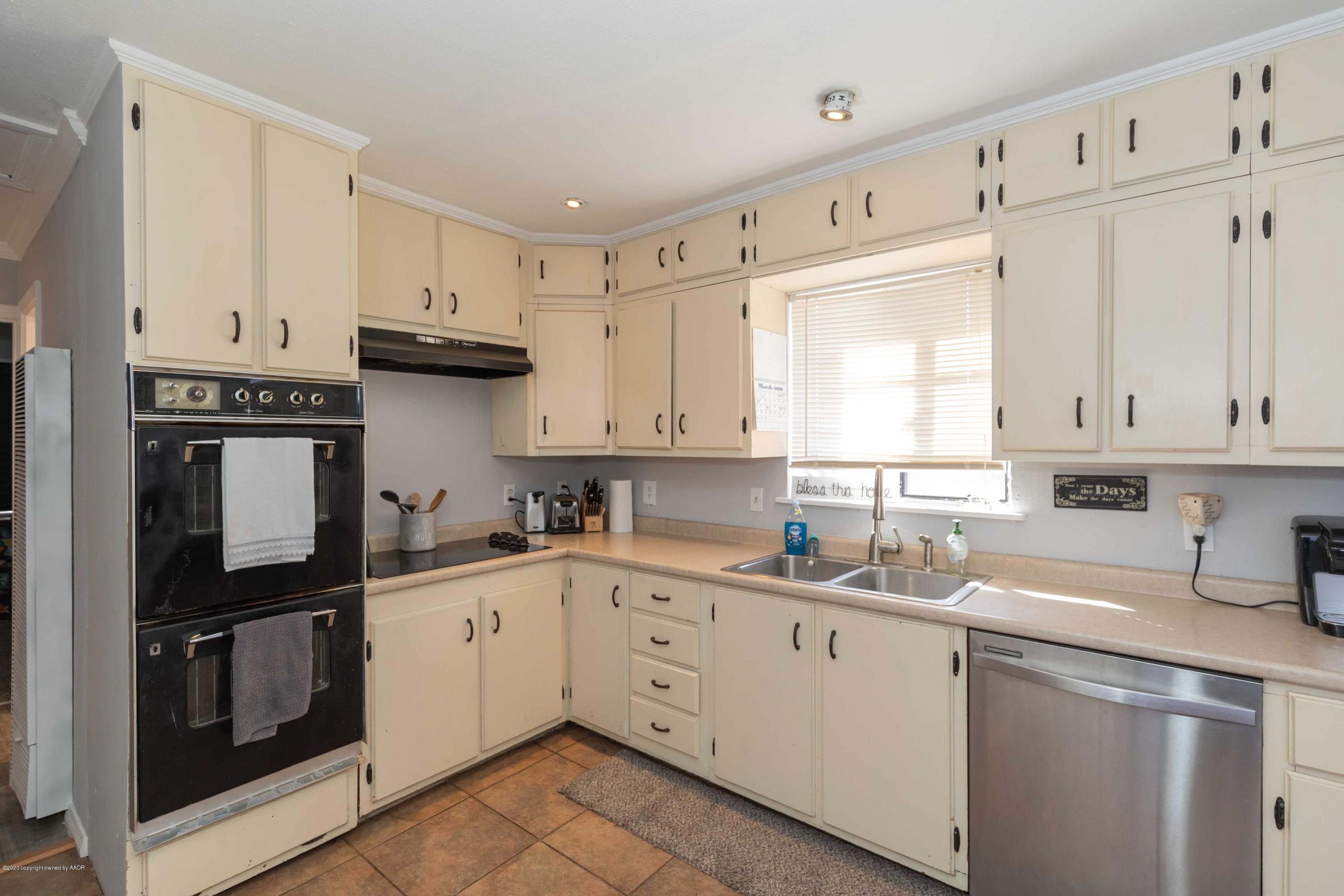 3623 South Hayden Street Amarillo, TX 79110 - Photo 25 of 28 a kitchen with cabinets appliances a sink and a window