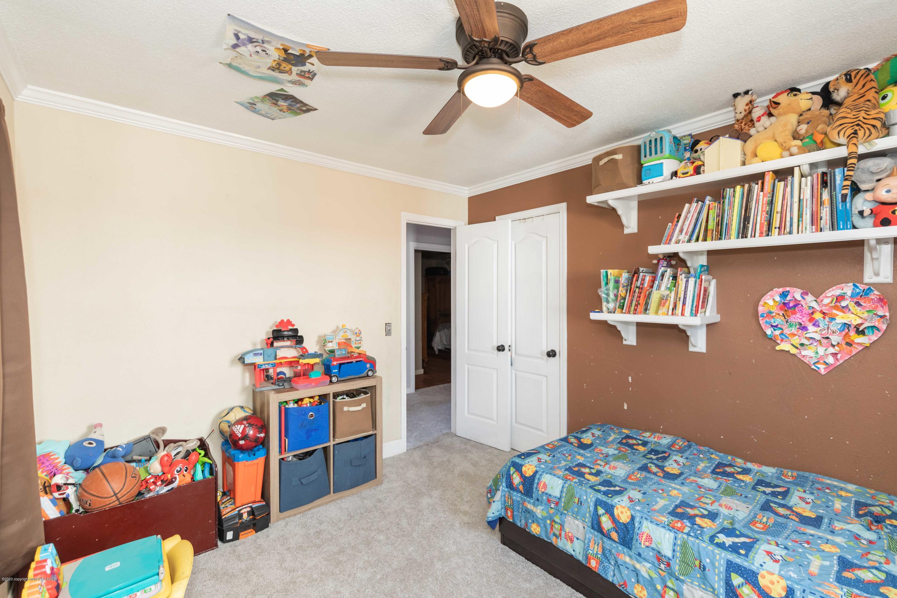 3623 South Hayden Street Amarillo, TX 79110 - Photo 8 of 28 a bedroom with a bed and a book shelf