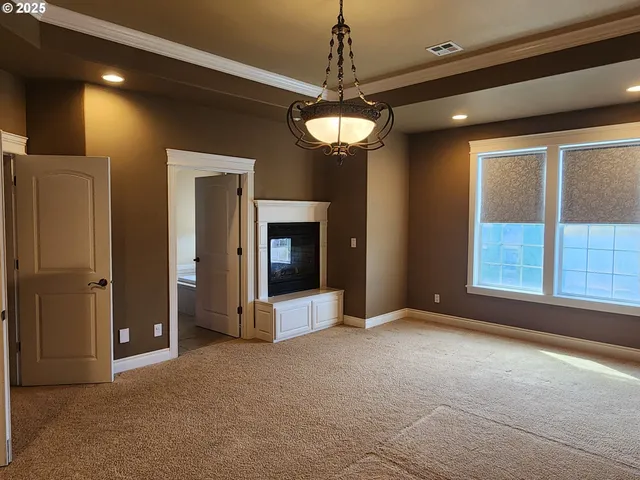 a view of a livingroom with a chandelier fan and windows