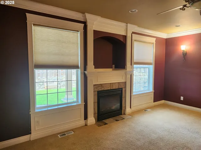 an empty room with windows fire place and an entrance