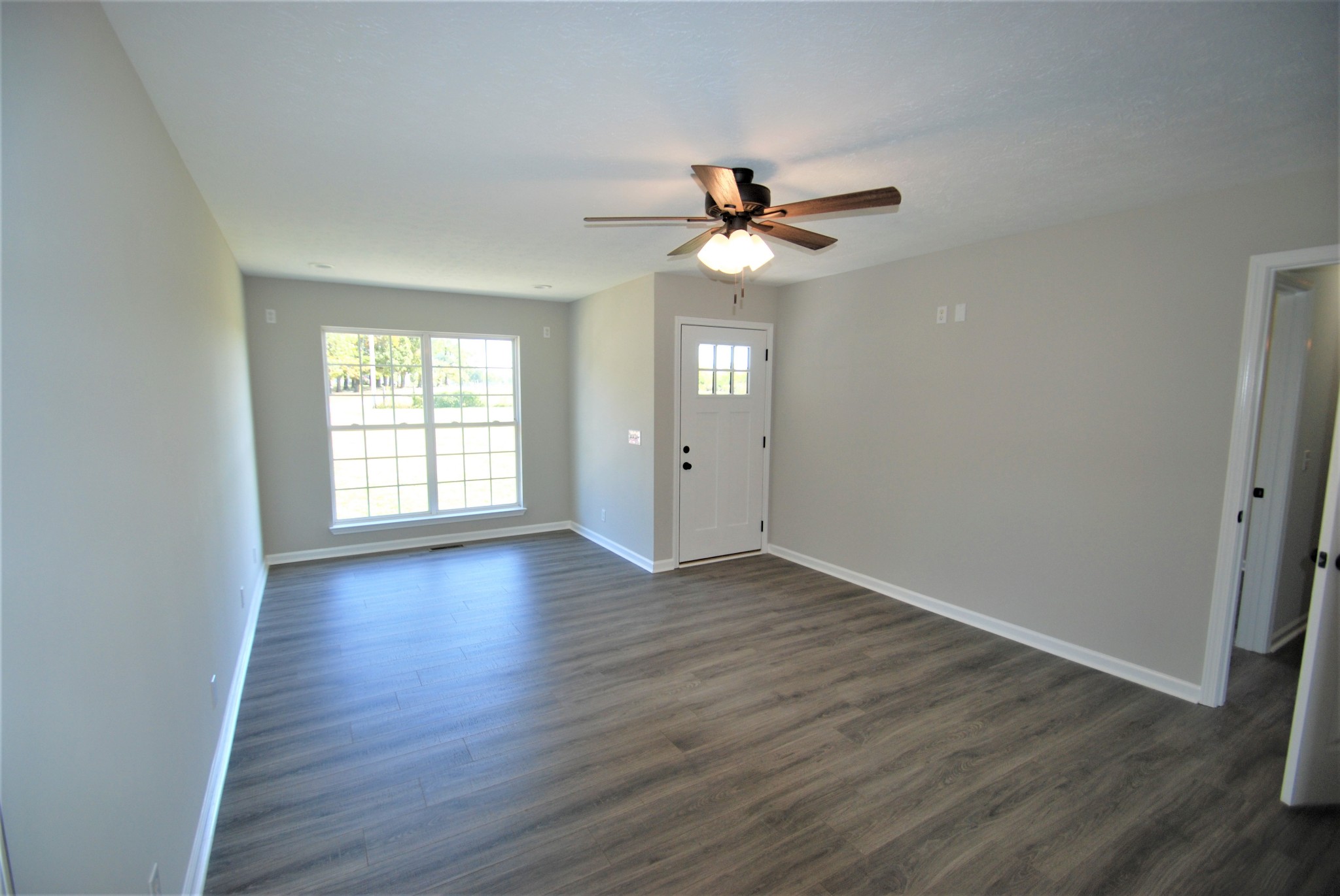 5178 Youngville Road Springfield, TN 37172 - Photo 3 of 12 an empty room with wooden floor chandelier fan and windows