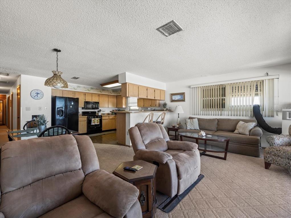 18218 Sunset Boulevard, Unit A St. Petersburg, FL 33708 - Photo 33 of 48 a living room with furniture and a chandelier