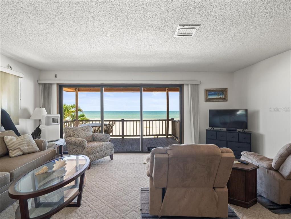 18218 Sunset Boulevard, Unit A St. Petersburg, FL 33708 - Photo 34 of 48 a living room with furniture and a flat screen tv