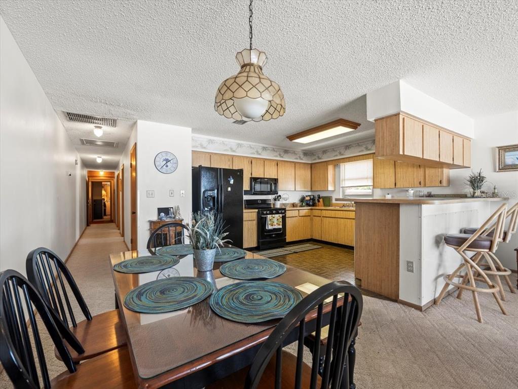 18218 Sunset Boulevard, Unit A St. Petersburg, FL 33708 - Photo 35 of 48 a view of a dining room with furniture and a kitchen