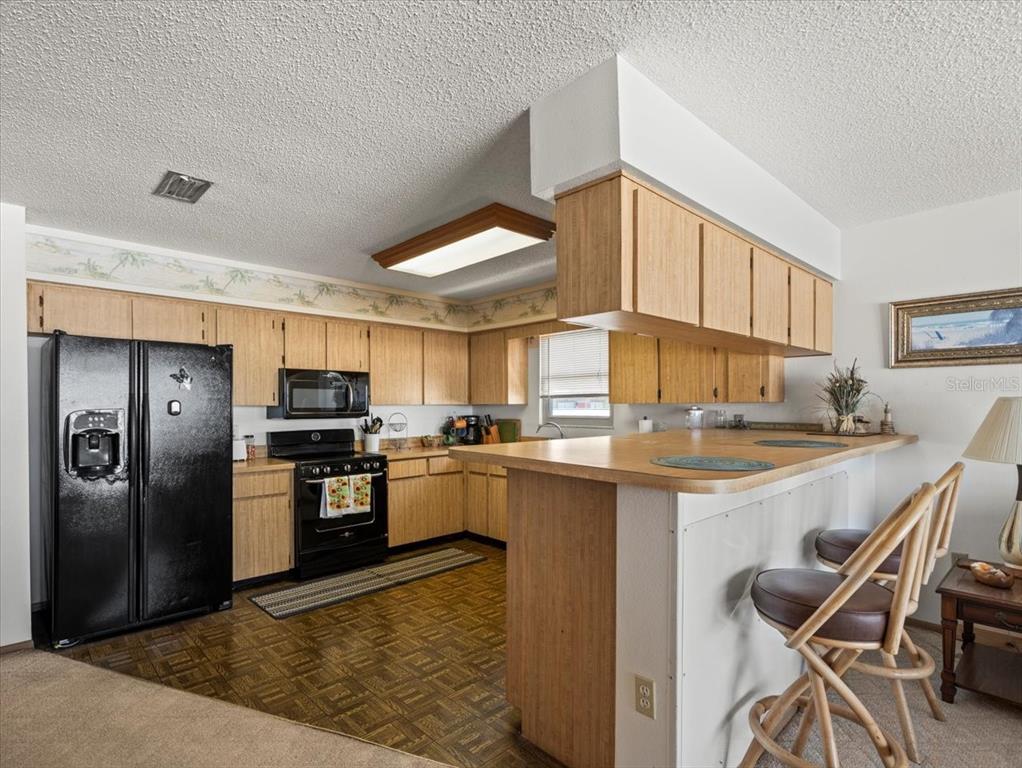 18218 Sunset Boulevard, Unit A St. Petersburg, FL 33708 - Photo 37 of 48 a kitchen with stainless steel appliances granite countertop a stove refrigerator sink and cabinets