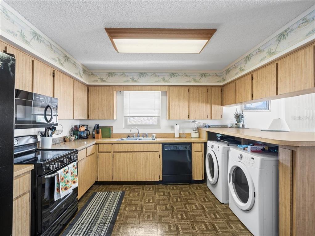 18218 Sunset Boulevard, Unit A St. Petersburg, FL 33708 - Photo 38 of 48 a kitchen with a sink a stove top oven and cabinets